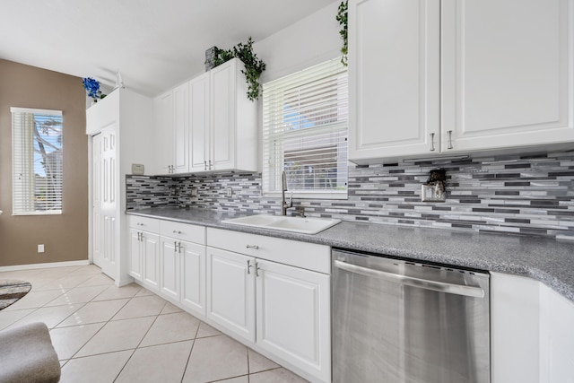 kitchen featuring tasteful backsplash, light tile patterned floors, stainless steel dishwasher, white cabinets, and sink