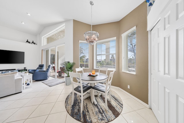 tiled dining room with a chandelier and lofted ceiling