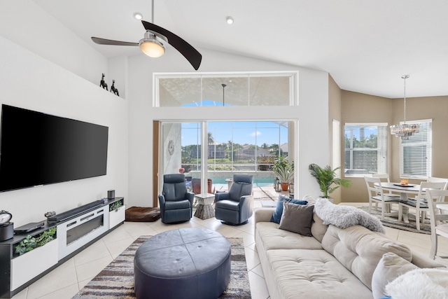 tiled living room with ceiling fan with notable chandelier