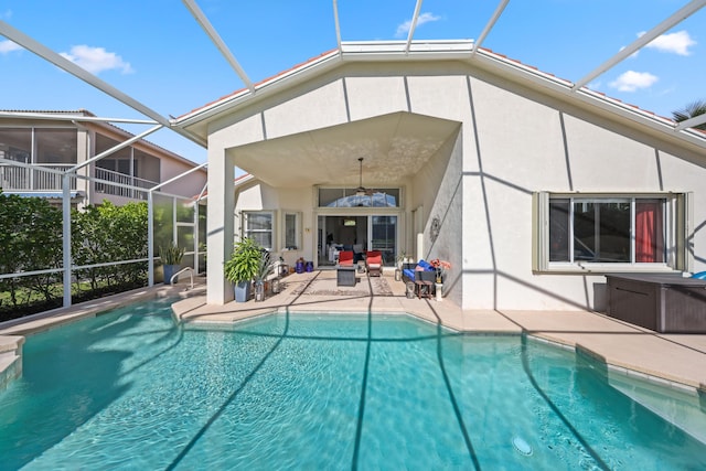 view of swimming pool featuring ceiling fan, a patio area, and a lanai