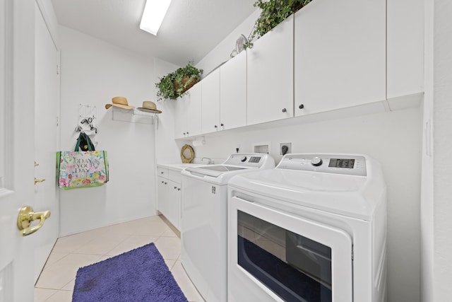 laundry area featuring light tile patterned flooring, sink, cabinets, and washer and dryer