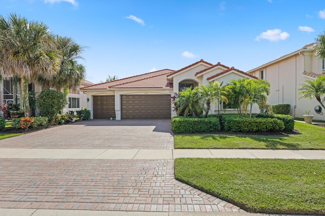 mediterranean / spanish-style home with a garage and a front lawn