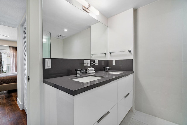 bathroom featuring decorative backsplash, vanity, and wood-type flooring