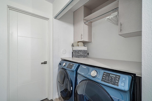 laundry room with cabinets and washer and dryer