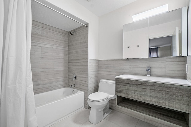 full bathroom featuring vanity, tile patterned flooring, toilet, shower / bathtub combination with curtain, and tile walls