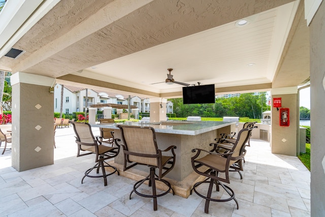 view of patio with an outdoor bar and ceiling fan