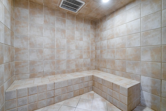 bathroom featuring tile patterned floors, a shower, and tile walls