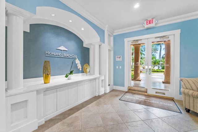 entrance foyer with ornate columns, french doors, light tile patterned floors, and ornamental molding