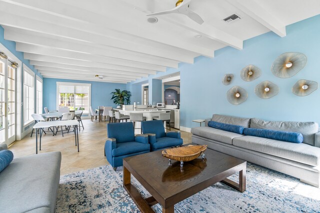 living room with ceiling fan, beam ceiling, and light tile patterned floors