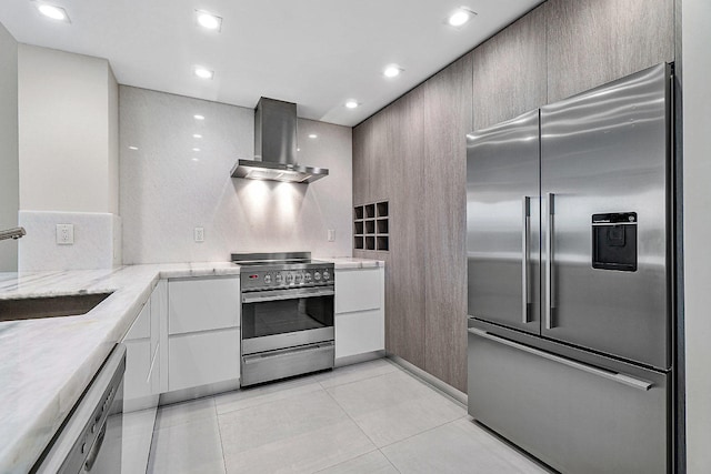 kitchen featuring light tile patterned flooring, sink, wall chimney exhaust hood, and stainless steel appliances