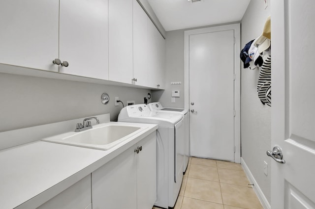 laundry room with cabinets, sink, light tile patterned flooring, and washing machine and clothes dryer