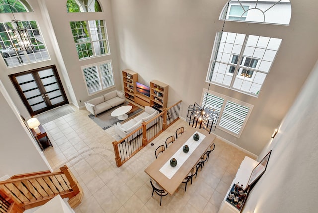 tiled living room with a high ceiling and french doors