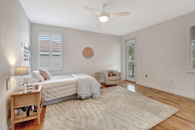 bedroom with hardwood / wood-style floors, ceiling fan, and access to exterior