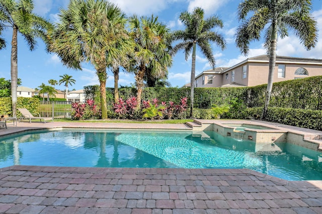 view of swimming pool with an in ground hot tub