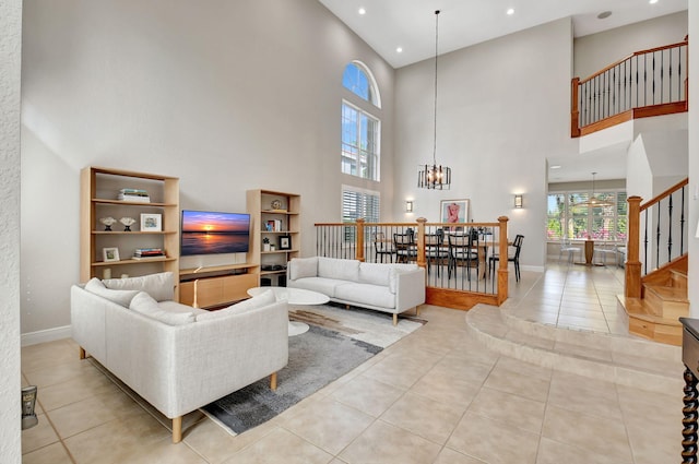 living room featuring light tile patterned floors, a high ceiling, and an inviting chandelier