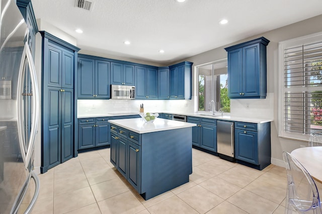 kitchen featuring blue cabinets, sink, and appliances with stainless steel finishes