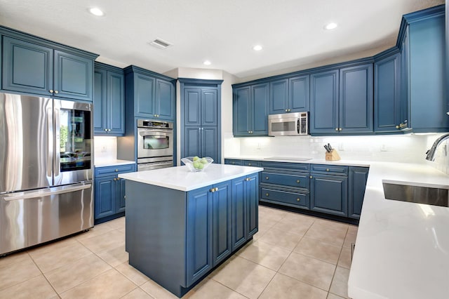 kitchen with a kitchen island, sink, blue cabinetry, and appliances with stainless steel finishes