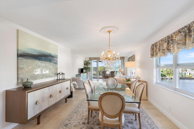 dining area with light tile patterned floors, baseboards, and a notable chandelier