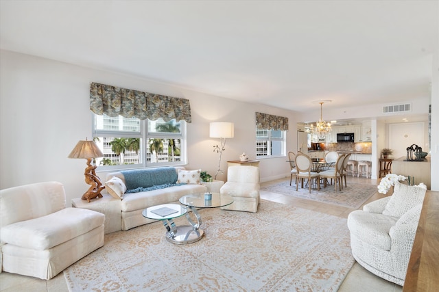 living room with a healthy amount of sunlight, tile patterned flooring, visible vents, and a chandelier