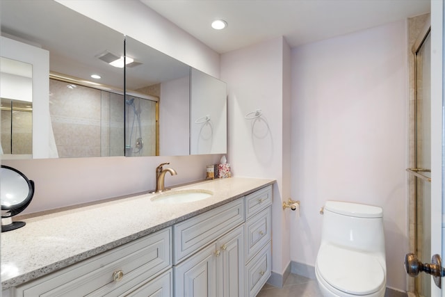 bathroom featuring tile patterned flooring, vanity, toilet, and an enclosed shower