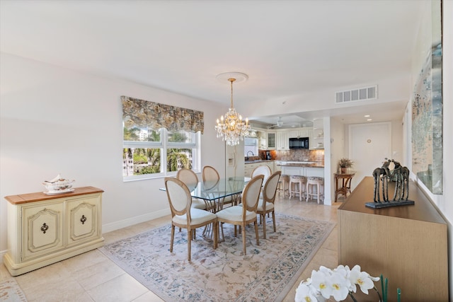 dining area featuring a chandelier, sink, and light tile patterned flooring