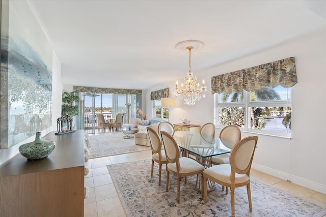 tiled dining room with a water view, plenty of natural light, and a notable chandelier