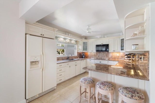 kitchen featuring open shelves, a sink, black appliances, a peninsula, and glass insert cabinets