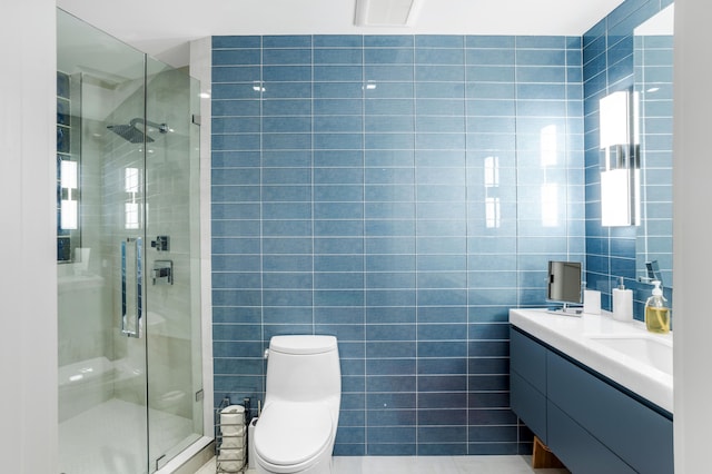 bathroom with toilet, an enclosed shower, tile walls, and vanity