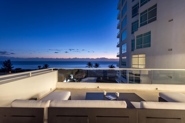 exterior space featuring outdoor lounge area, a water view, and a balcony