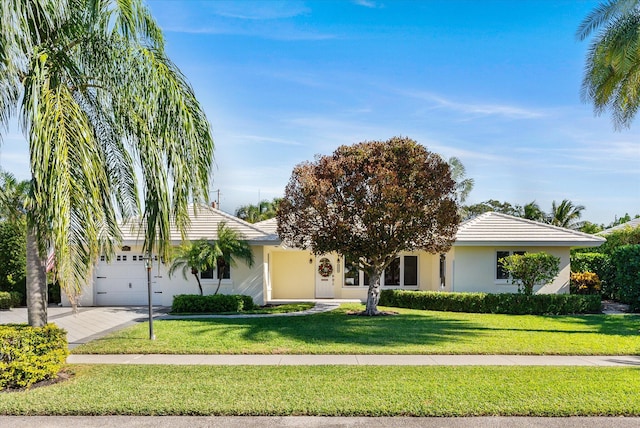 view of front of property featuring a garage and a front lawn