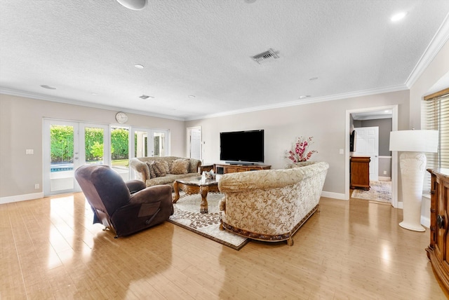 living room with a textured ceiling, light hardwood / wood-style flooring, and ornamental molding