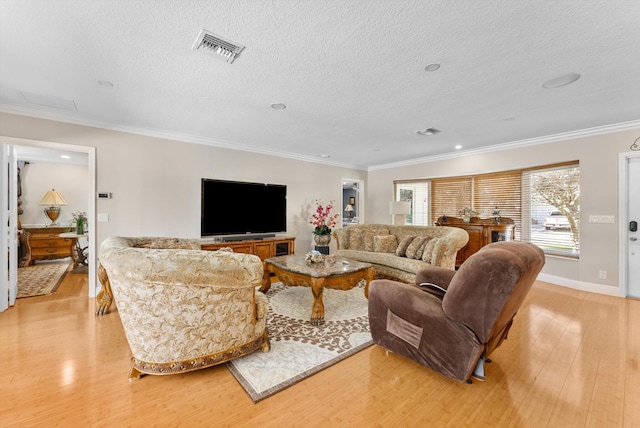 living room with light hardwood / wood-style flooring, a textured ceiling, and ornamental molding