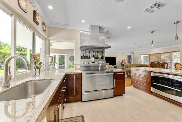 kitchen with light stone countertops, appliances with stainless steel finishes, ornamental molding, extractor fan, and sink