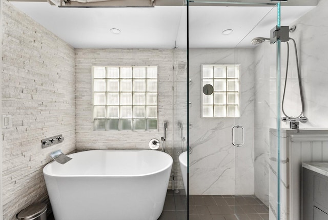 bathroom featuring tile patterned flooring, tile walls, and shower with separate bathtub