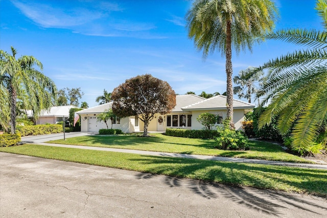 ranch-style house with a garage and a front lawn