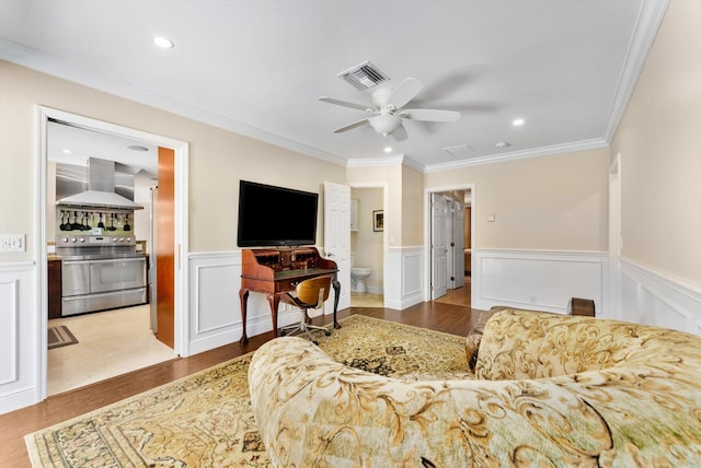 living room featuring wood-type flooring, ceiling fan, and ornamental molding