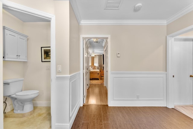 corridor featuring light hardwood / wood-style floors and crown molding