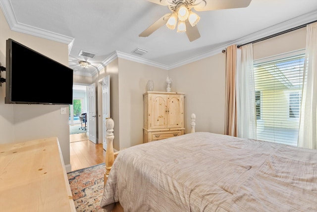 bedroom with hardwood / wood-style flooring, ceiling fan, and crown molding