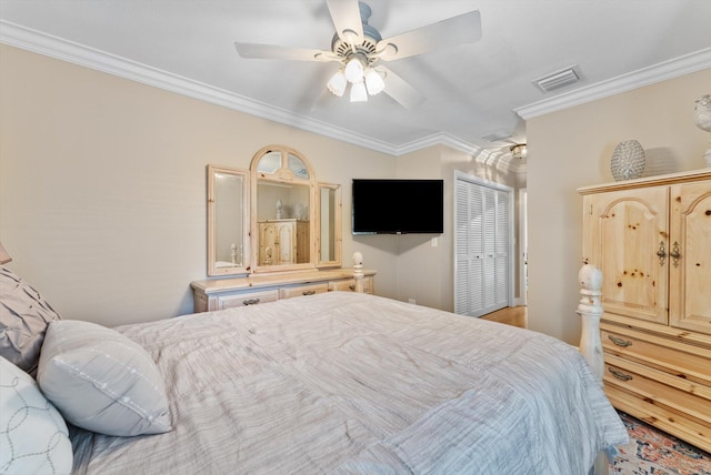 bedroom featuring ceiling fan, crown molding, and a closet