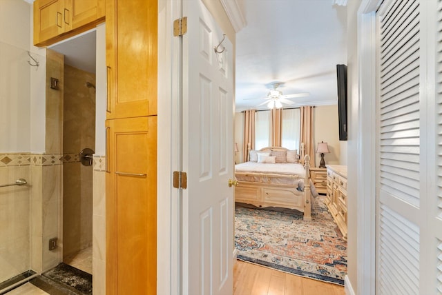 bedroom with ceiling fan, ornamental molding, and light wood-type flooring