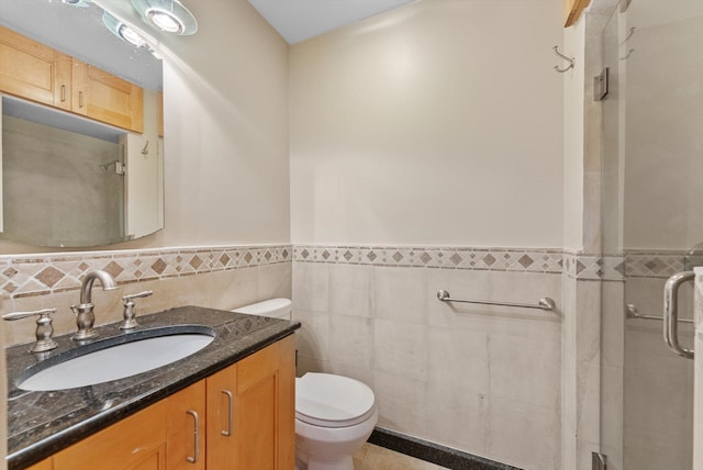 bathroom with vanity, tile walls, and toilet