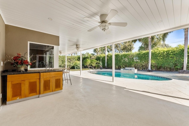 view of swimming pool featuring exterior bar and a patio area