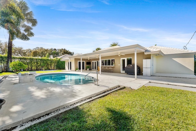 view of pool with a yard, ceiling fan, a patio area, and a grill