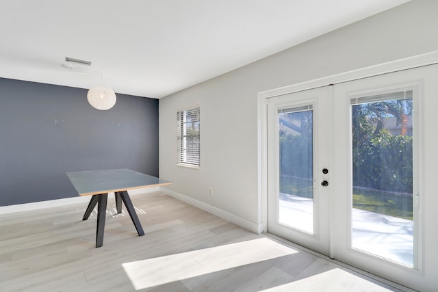 unfurnished dining area with french doors, light hardwood / wood-style floors, and a wealth of natural light