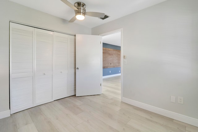 unfurnished bedroom featuring a closet, light hardwood / wood-style flooring, and ceiling fan