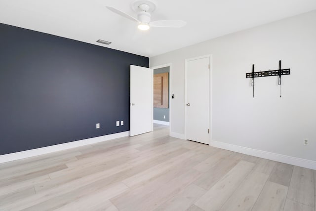 empty room featuring ceiling fan and light hardwood / wood-style flooring