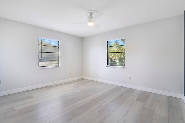 empty room with plenty of natural light, ceiling fan, and light wood-type flooring