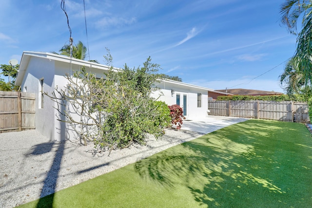 back of property featuring a lawn and a patio area