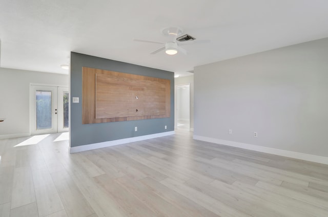 unfurnished room featuring ceiling fan, french doors, and light wood-type flooring