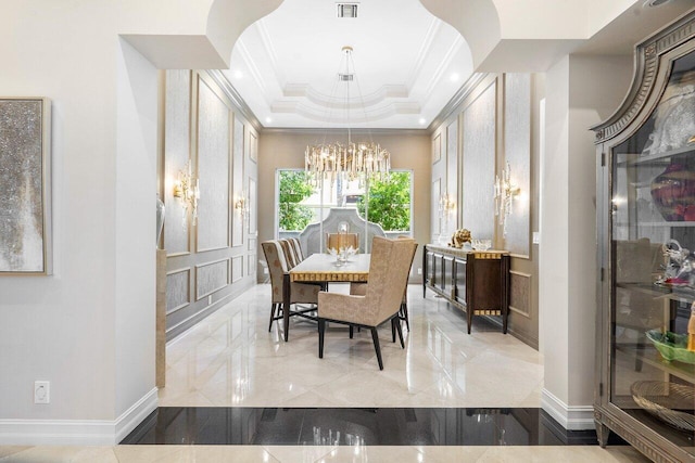 dining space featuring a notable chandelier, ornamental molding, and a tray ceiling